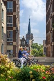 Man en vrouw fietsen over de IJsselkade in Doesburg