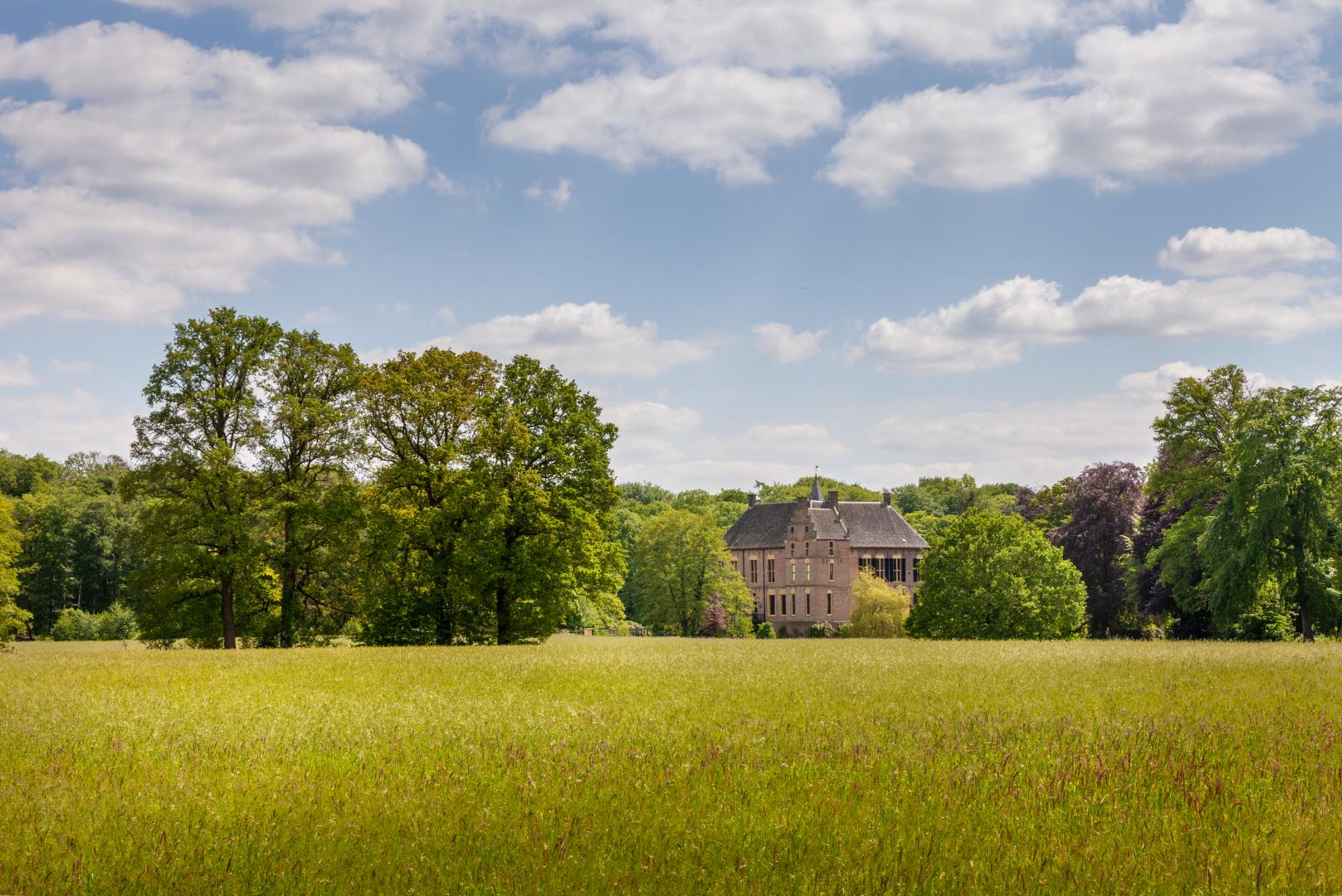 Kasteel Vorden in Laag Keppel, gemeente Bronckhorst. Van een afstand met ervoor een akker met graan.